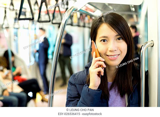 Woman talk to mobile phone inside train station