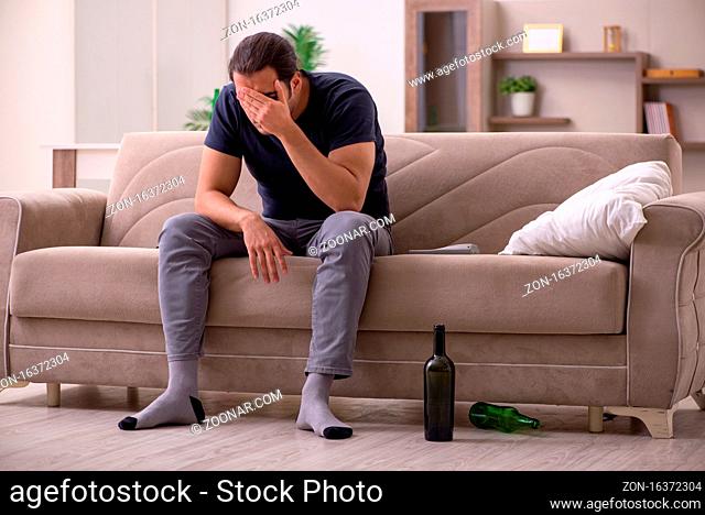 Young alcoholic suffering at home