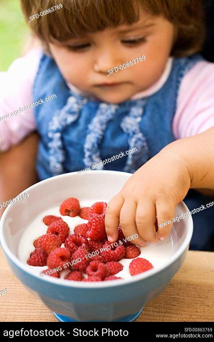Small girl with raspberry yoghurt