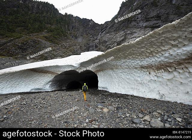 Hikers at the entrance of an ice cave of a glacier, Big Four Ice Caves, Okanogan-Wenatchee National Forest, Washington, USA, North America