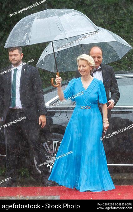25 July 2023, Bavaria, Bayreuth: Ursula von der Leyen (CDU), President of the EU Commission, and husband Heiko (r) arrive in the rain for the opening of the...