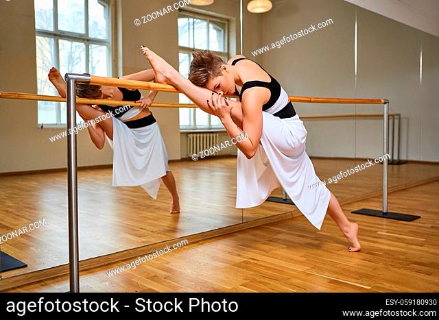 beautiful young tango dancer woman in black and white dress excersizing in dancing studio mirror room. copy space