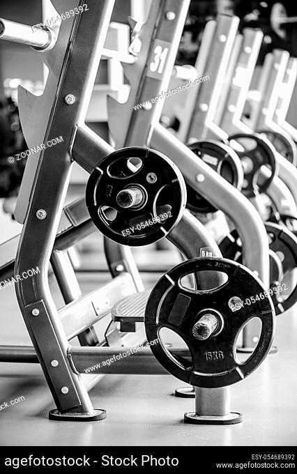 Modern gym interior with bench press equipment in a row, black and white version
