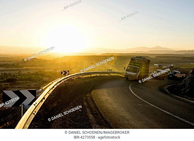 Loaded truck on curvy road in Dades Valley at sunset, Ouarzazate, Morocco