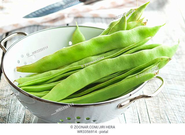 Green string beans pods in colander