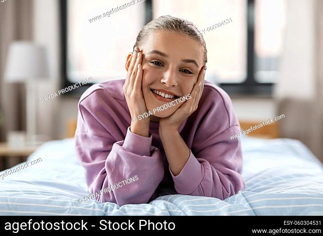 happy smiling girl lying on bed at home