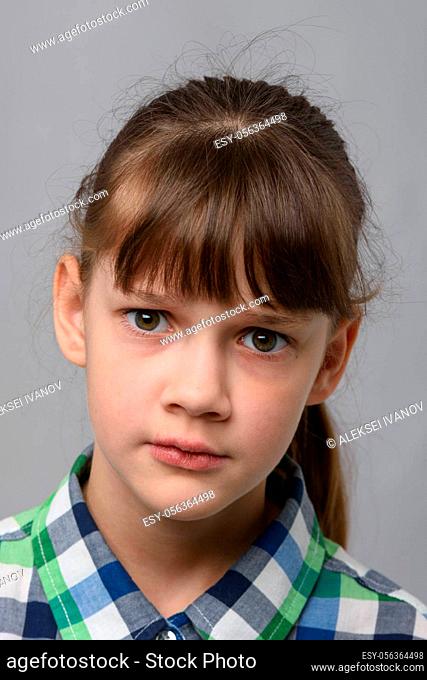 Portrait of a perplexed ten-year-old girl of European appearance, close-up