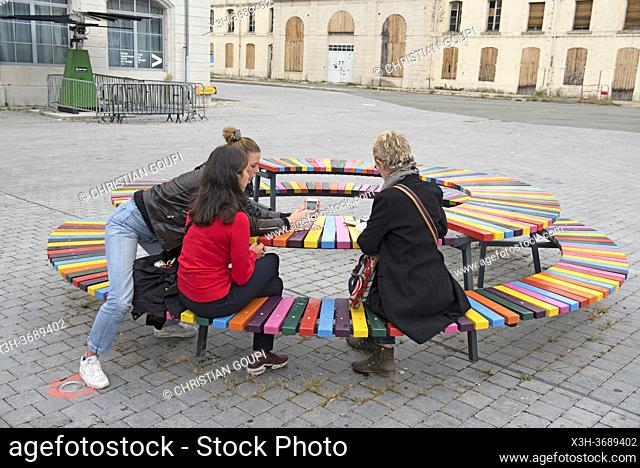 gens assis sur un ""Banc d'essai"", a l'occasion de la Biennale internationale du design certains des projets, elus par les habitants, sont mis en service