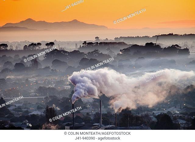 Winter dawn over industrial chimneys, Christchurch, Seaward Kaikoura range behind, New Zealand