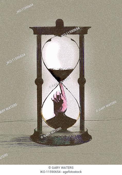 Hand inside of hourglass stopping time running out