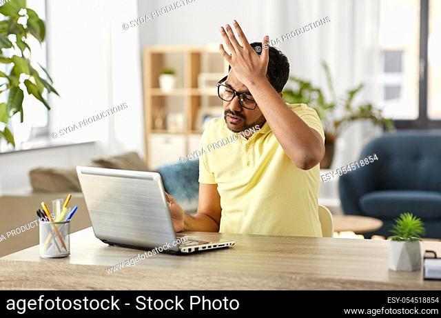 stressed man with laptop working at home office