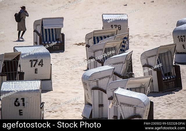 02 May 2023, Mecklenburg-Western Pomerania, Heringsdorf: Shuttered beach chairs stand on the beach of the Baltic resort of Heringsdorf on the Baltic island of...