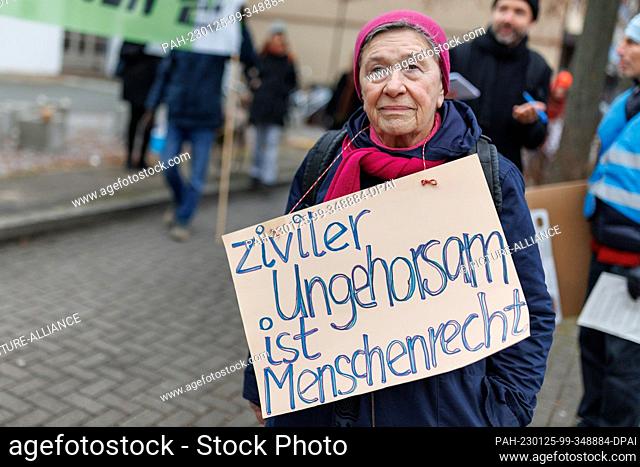25 January 2023, Bavaria, Nuremberg: A climate activist protests next to the Nuremberg District Court during a trial against four climate activists for coercion