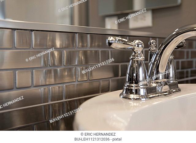 Close-up of faucet and metallic backsplash in bathroom; Murrieta; California; USA