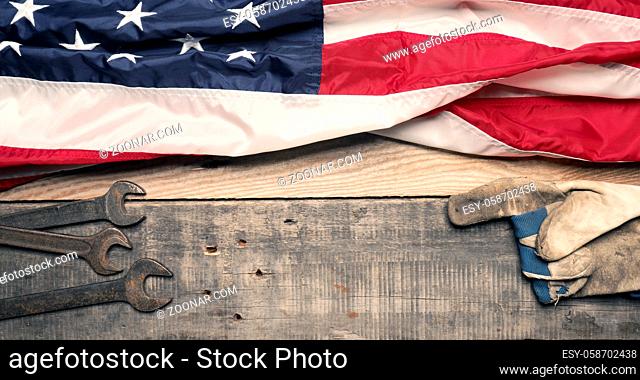 Labor Day concept, Flag of the United States with tools on a wooden workbench