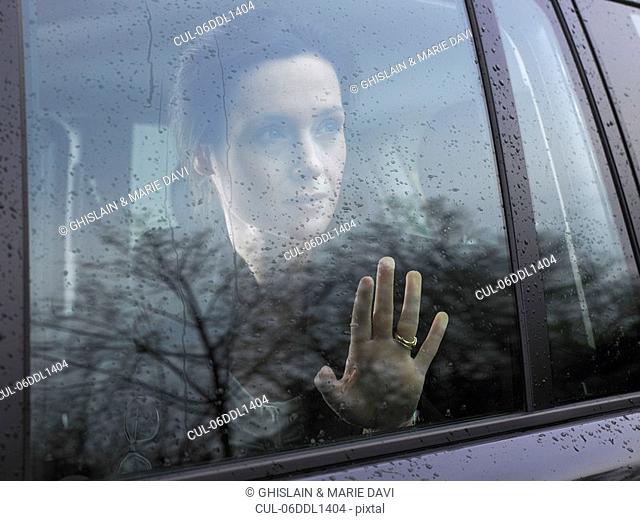Woman looking through a car's window