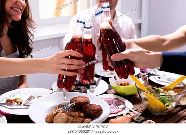 Group Of Happy Young Friends Celebrating With Bottle Of Lemonade Drink