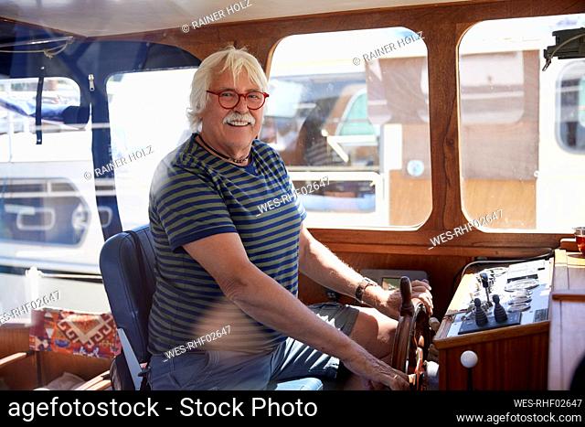 Senior man wearing eyeglasses sailing boat