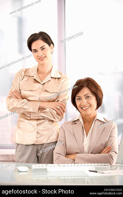 Portrait of businesswomen in office, smiling at camera