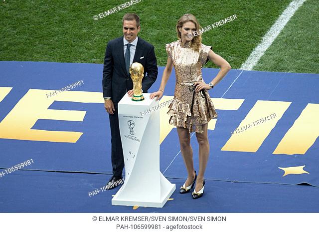 Philipp LAHM (left, former Fuvuball professional) and a Russian model with World Cup trophy, cup, trophies, trophies, full figure