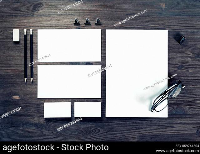 Photo of blank corporate stationery on wood table background. Branding mock-up. Top view. Flat lay
