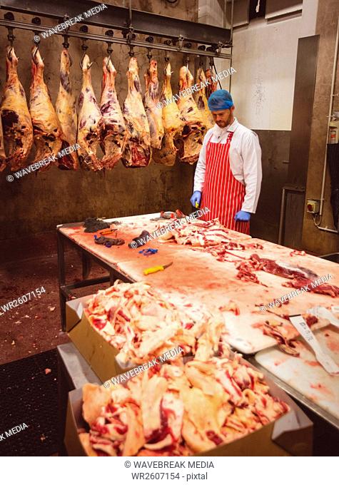 Butcher working in meat storage room