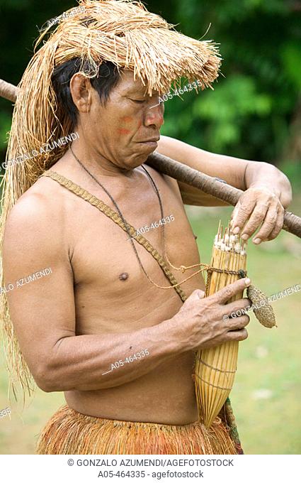 Indigenous man preparing blowpipe. Yaguas Community. Amazonas. Peru