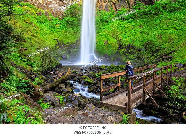 USA, Oregon, Multnomah County, Columbia River Gorge, Elowah Falls, Female tourist standing on bridge