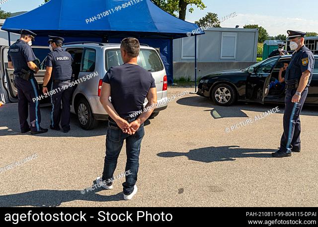 11 August 2021, Bavaria, Piding: Police officers check a car from abroad at the Piding Nord checkpoint on the A8 in the direction of Munich