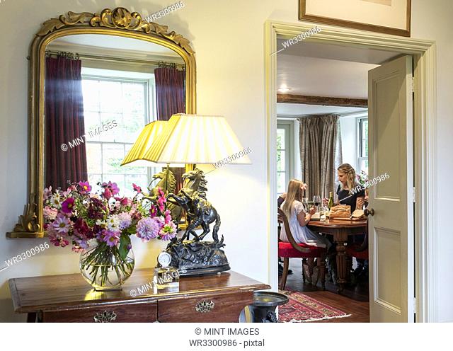 Doorway to Caucasian mother and daughter eating in dining room