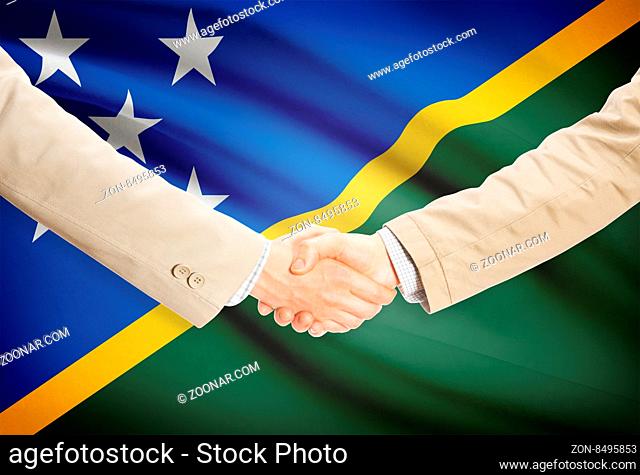 Businessmen shaking hands with flag on background - Solomon Islands