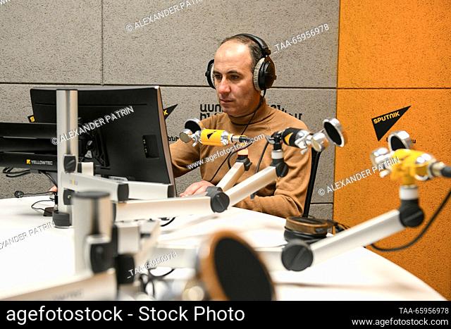 ARMENIA, YEREVAN - 21 de diciembre de 2023: El anfitrión de radio Hovhannes Shoghikyan es visto en un estudio de Sputnik Armenia