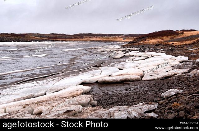 Typical Icelandic frozen lake with big ice cubes in the island of Iceland early in spring time
