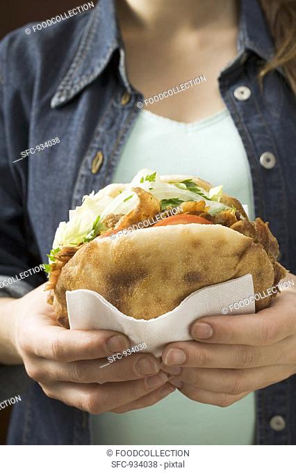 Young woman holding döner kebab in her hands