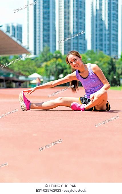 Woman doing warm up exercise in sport stadium
