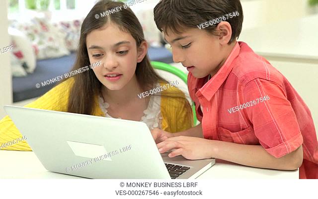 Boy and girl using laptop at home together.Shot on Canon 5d Mk2 with a frame rate of 25fps