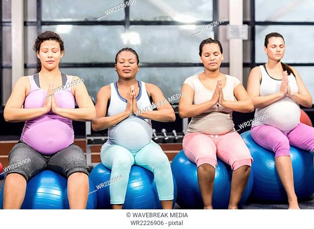 Cheerful pregnant women exercising on fitness balls