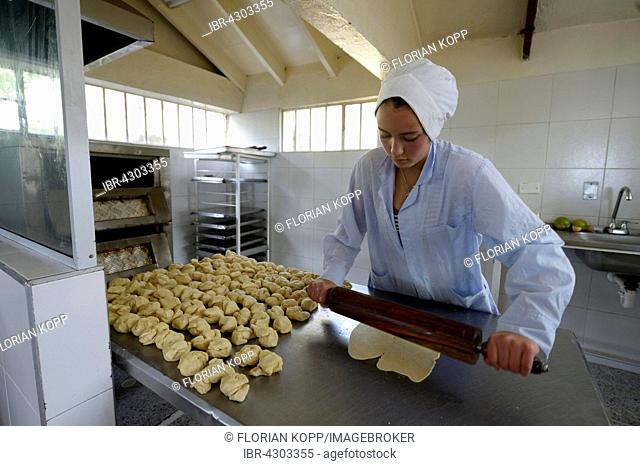 Teen rolling out dough in the bakery of a social project, Bogota, Colombia
