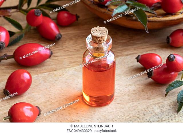 A bottle of rose hip seed oil with fresh ripe berries