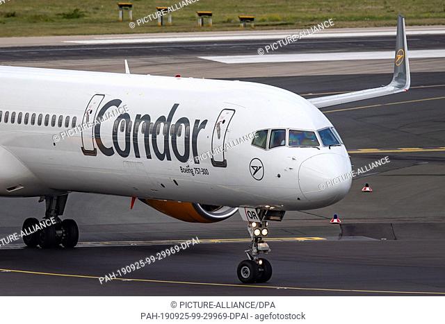 25 September 2019, North Rhine-Westphalia, Duesseldorf: A Condor aircraft rolls over the apron at Düsseldorf Airport. The holiday airline Condor