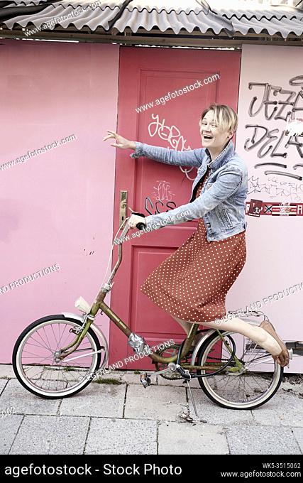 Motivated woman on bicycle pointing forward direction