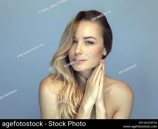 Beautiful woman fashion portrait. Perfect smooth skin and long blond hair. Natural makeup. Spa