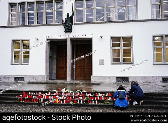 31 January 2022, Baden-Wuerttemberg, Heidelberg: Two women light candles in front of the New University building. One week after the rampage