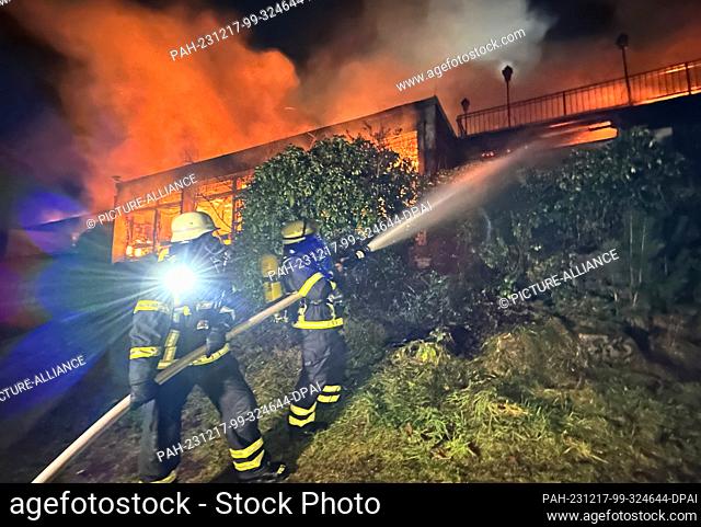17 December 2023, Hamburg: Firefighters spray water into the flames of a fire in a vacant hotel. The emergency services were called to the fire in the Harburg...