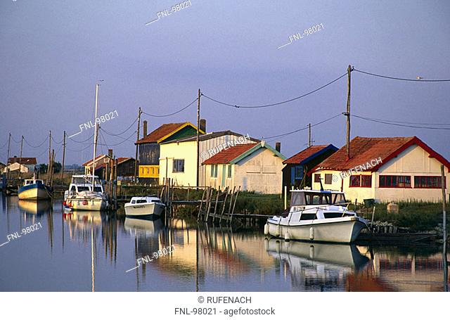 Reflection of boats and houses in water, La Tremblade, Charentes-Maritime, France