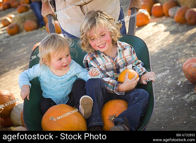 Adorable young family enjoys a day at the pumpkin patch