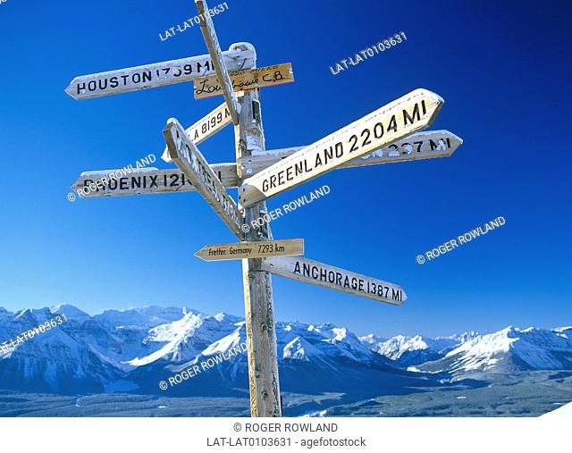 The Top of the World Chair chair lift ride up to the mountain top of the winter sports resort at Lake Louise has a signpost with names and distances of some far...