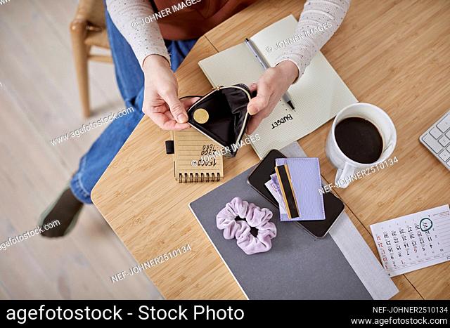 Woman's hands holding empty wallet, high angle view