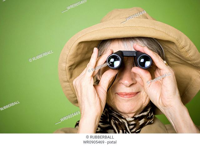 Close-up of an elderly woman looking through a pair of binoculars