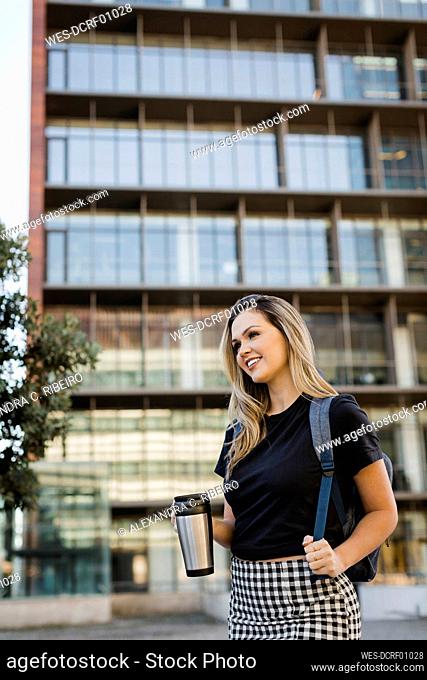 Thoughtful businesswoman with insulated coffee mug